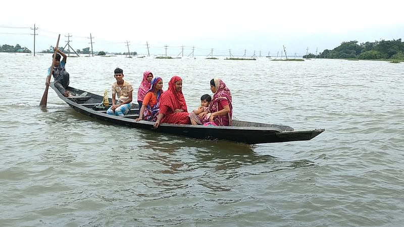 সুনামগঞ্জ সদর উপজেলার চেকনিকারা-ইসলামপুর সড়কে পানি থাকায় নৌকায় গ্রামে যাচ্ছেন লোকজন। আজ বৃহস্পতিবার সকালে