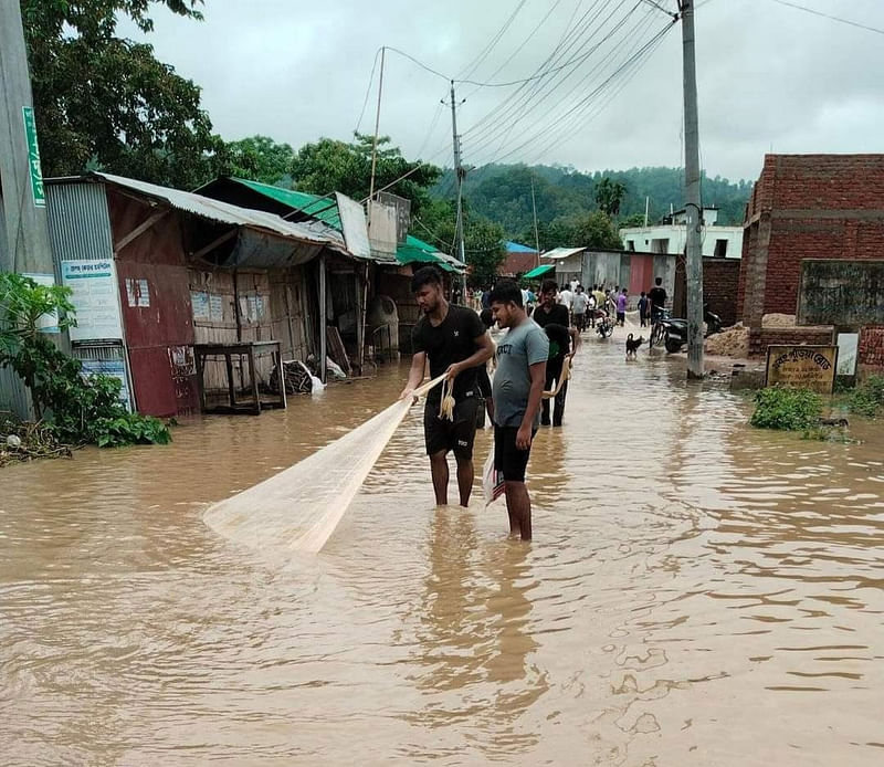 টানা বৃষ্টিতে খাগড়াছড়ির নিম্নাঞ্চল ডুবে গেছে। ডুবে যাওয়া সড়কে মাছ ধরছেন কয়েকজন। ছবিটি শহরের দক্ষিণ খবংপুড়িয়া এলাকা থেকে তোলা