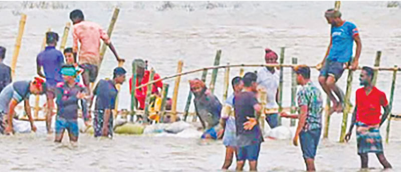 খুলনার পাইকগাছায় ক্ষতিগ্রস্ত বাঁধ মেরামতের চেষ্টা করছেন এলাকাবাসী