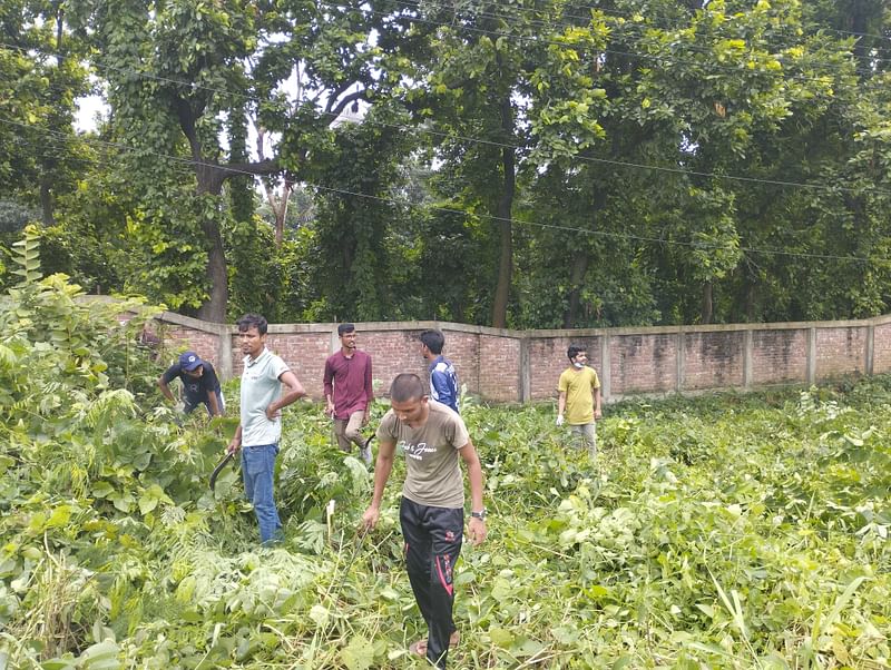 জাহাঙ্গীরনগর বিশ্ববিদ্যালয়ের মীর মশাররফ হোসেন হলের ফটকসংলগ্ন ঢাকা-আরিচা মহাসড়কের পাশে ছিনতাইপ্রবণ এলাকার জঙ্গল পরিষ্কার করছেন শিক্ষার্থীরা। আজ বৃহস্পতিবার দুপুরে