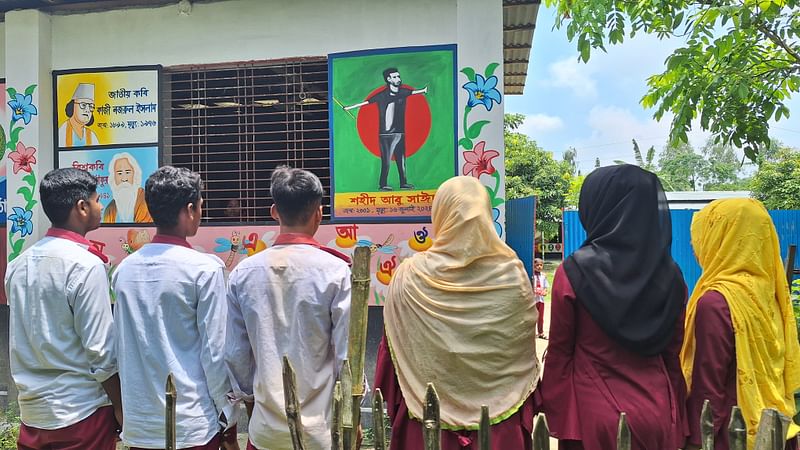 শ্রেণিকক্ষের দেয়ালে আঁকা আবু সাঈদের ছবি দেখছেন শিক্ষার্থীরা। দিনাজপুরের বিরামপুর উপজেলার কাটলা মেধাবিকাশ স্কুলে