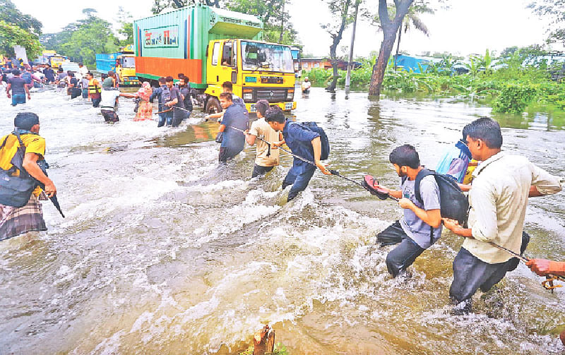 আকষ্মিক বৃষ্টি ও বন্যার পানিতে ডুবে গেছে ঢাকা-চট্টগ্রাম মহাসড়কের অনেক এলাকা। আটকে পড়েছে বহু যানবাহন। পানির স্রোত থেকে বাঁচতে দড়ি ধরে মহাসড়ক পার হয়ে নিরাপদ স্থানের দিকে যাওয়ার চেষ্টায় সাধারণ মানুষ। গতকাল বিকেল সাড়ে চারটায় ফেনীর লালপোল এলাকায়