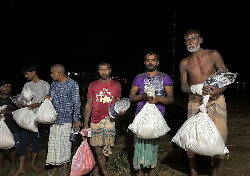 প্রথম আলো ট্রাস্টের দেওয়া ত্রাণ নিয়ে ফিরছেন গ্রামবাসী। আজ বিকেলে  চট্টগ্রামের ফটিকছড়ি উপজেলার ১০ নম্বর সুন্দরপুর ইউনিয়নের ৯ নম্বর ওয়ার্ডে