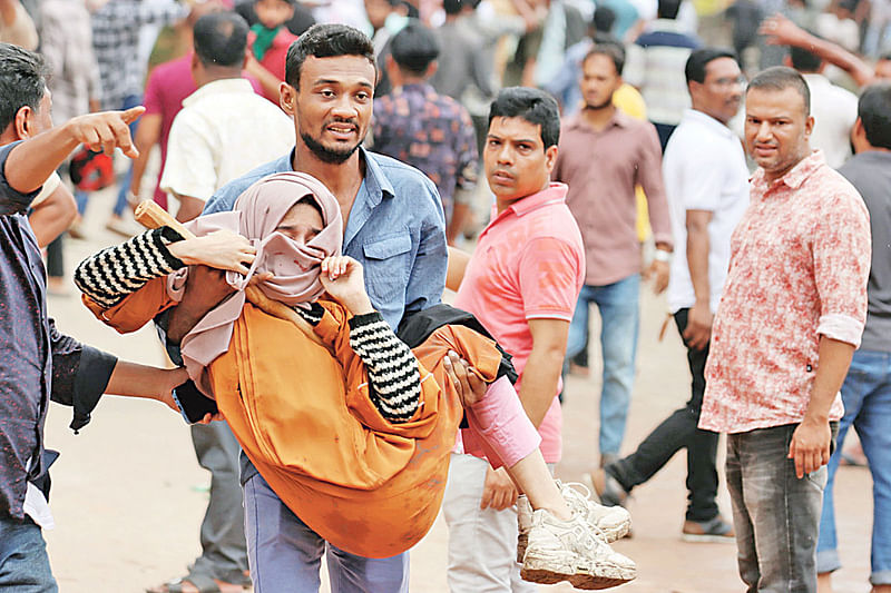 বৈষম্যবিরোধী ছাত্র আন্দোলনে আহত এক শিক্ষার্থীকে নিয়ে যাচ্ছেন কয়েকজন। ৩ আগস্ট কুমিল্লার পুলিশ লাইনস এলাকায়