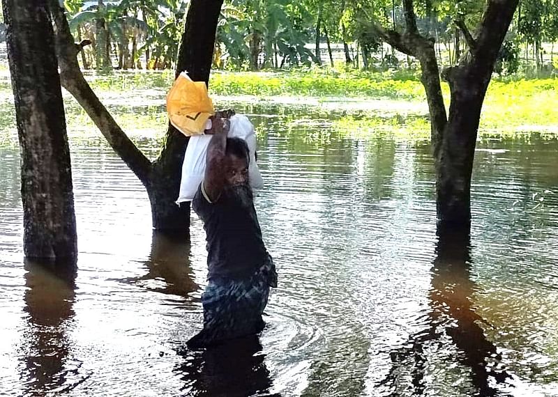 নোয়াখালীর বেগমগঞ্জ উপজেলার বারগাঁও ইউনিয়নের রাজিবপুর গ্রামে ত্রাণ নিয়ে ফিরছেন এক ব্যক্তি। গতকাল মঙ্গলবার দুপুরে