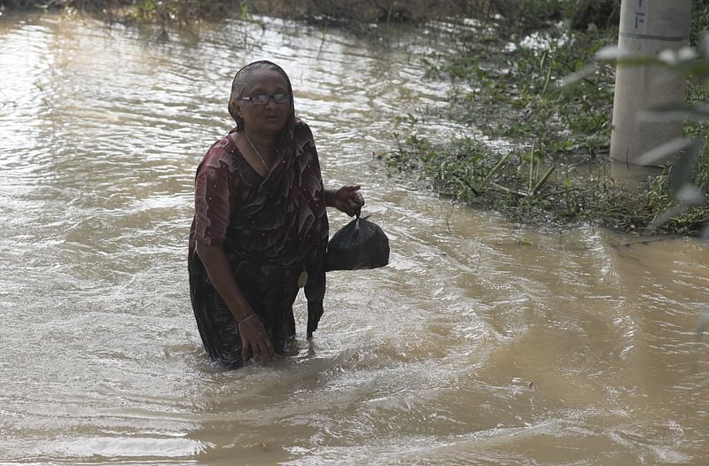 ত্রাণ সংগ্রহ করে বাড়ির দিকে যাচ্ছেন এক নারী। শুক্রবার ফেনীর সোনাগাজী উপজেলার চিত্র