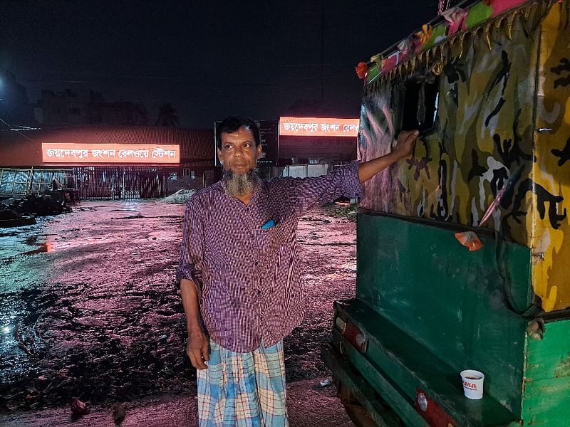 বন্ধ রেলস্টেশনের সামনে যাত্রীর অপেক্ষায় দেলোয়ার হোসেন। বুধবার রাতে গাজীপুরের জয়দেবপুর রেলস্টেশন এলাকায়