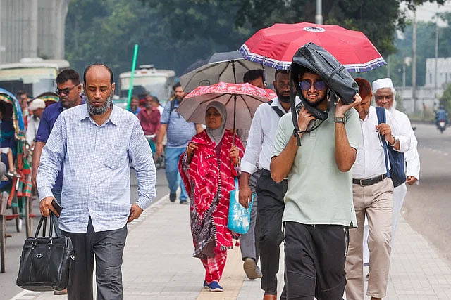 রোদ থেকে বাঁচতে হাতের ব্যাগটিকে মাথার ওপর ধরে আছেন এক ব্যক্তি। আগারগাঁও, ঢাকা