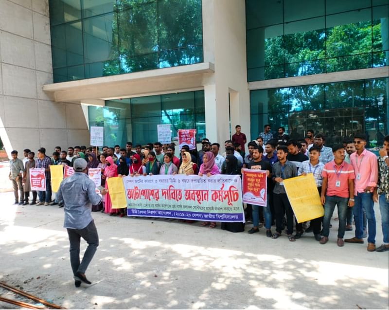 সেশনজটের কারণে ৩ বছরের ডিগ্রি ৬ বছরে রূপান্তর করা ও অটো পাসের দাবিতে অবস্থান কর্মসূচি ও বিক্ষোভ করেছেন ডিগ্রির শিক্ষার্থীরা। আজ দুপুরে গাজীপুরের বোর্ডবাজার এলাকায় জাতীয় বিশ্ববিদ্যালয়ের মূল ক্যাম্পাসে অবস্থান কর্মসূচি পালন করেন শিক্ষার্থীরা