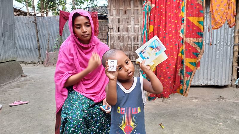 মায়ের পাশে দাঁড়িয়ে শিশু মোয়াজ তার বাবা বৈষম্যবিরোধী ছাত্র আন্দোলনে নিহত শাহাবুল ইসলামের ছবি দেখাচ্ছে। গত বুধবার বিকেলে পঞ্চগড়ের দেবীগঞ্জ উপজেলার মেলাপাড়া এলাকায়