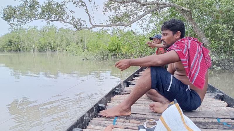 সুন্দরবনের নলবুনিয়া খালে বড়শি পেতে নৌকায় বসে মাছ শিকারের অপেক্ষায় বৈশেল জেলেরা। গত মঙ্গলবার তোলা