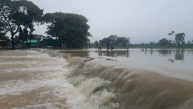 বন্যার পানিতে নেত্রকোনার কলমাকান্দা-বরুয়াকোনা সড়কের স্থানে স্থানে ডুবে ভেঙে গেছে। ছবিটি গত রোববার সকালে সড়কের চিনাহালা এলাকায় তোলা