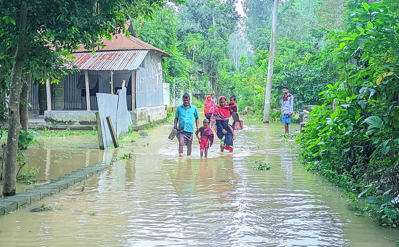 ডুবে যাওয়া সড়কের পানি মাড়িয়ে গন্তব্যে ছুটছেন স্থানীয় লোকজন। মঙ্গলবার বিকেলে কুড়িগ্রামের রৌমারী সদর উপজেলার ইজলামারী এলাকায়