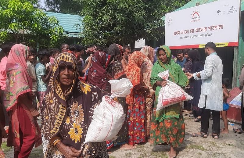 প্রথম আলো ট্রাস্টের ত্রাণসামগ্রী নিয়ে ফিরছেন বন্যার্ত মানুষেরা। আজ বৃহস্পতিবার দুপুরে কুড়িগ্রাম সদর উপজেলার ঘোগাদহ ইউনিয়নের প্রথম আলো চরে