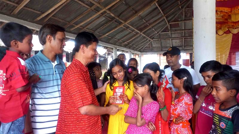 মন্দির চত্বরে প্রতিমা দর্শনার্থী শিশু-কিশোরদের মধ্যে বই উপহার দেয় জেলা হিন্দু যুব-ছাত্র মহাজোট ও সনাতন জাগরণ মঞ্চের সদস্যরা। শুক্রবার রাতে নাটোরের বড়াইগ্রামে