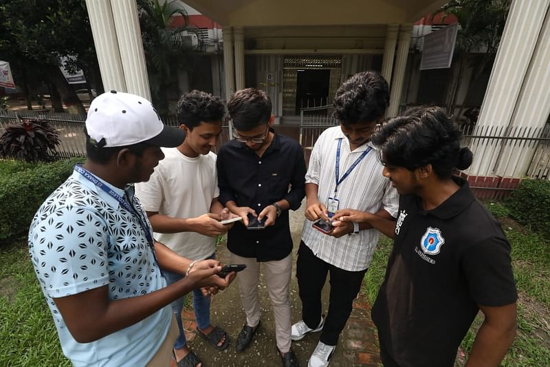 মুঠোফোনে ফলাফল দেখছেন শিক্ষার্থীরা। ঢাকা কলেজ, ১৫ অক্টোবর