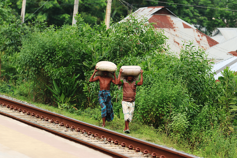 ভারত সীমান্তসংলগ্ন কুমিল্লার ব্রাহ্মণপাড়া উপজেলার শশীদল ইউনিয়নের সালদা নদী রেলস্টেশনের দিকে ভারতীয় চিনি মাথায় করে নিয়ে যাচ্ছেন দুজন শ্রমিক। গত শনিবার দুপুরে