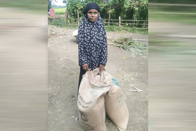 ভিডব্লিউবির ৯০ কেজি চাল নিয়ে বাড়িতে যাওয়ার জন্য সড়কের পাশে অপেক্ষা করছেন অনুপা। আজ বুধবার নান্দাইল উপজেলার চণ্ডীপাশা ইউপির অদূরে