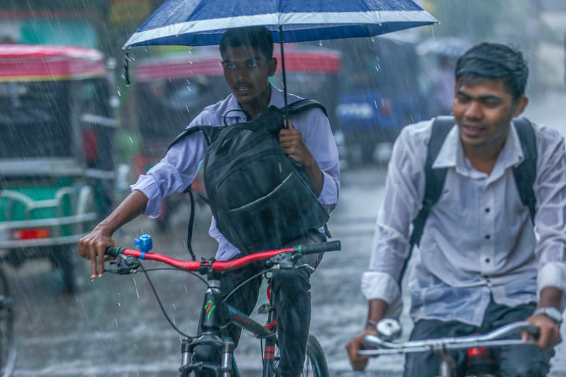 ঘূর্ণিঝড় ‘দানা’র প্রভাবে হালকা থেকে মাঝারি মাত্রায় বৃষ্টি হচ্ছে। বৃষ্টির মধ্যে সাইকেল চালিয়ে গন্তব্যে যাচ্ছে দুই শিক্ষার্থী। দৌলতপুর, খুলনা, ২৪ অক্টোবর