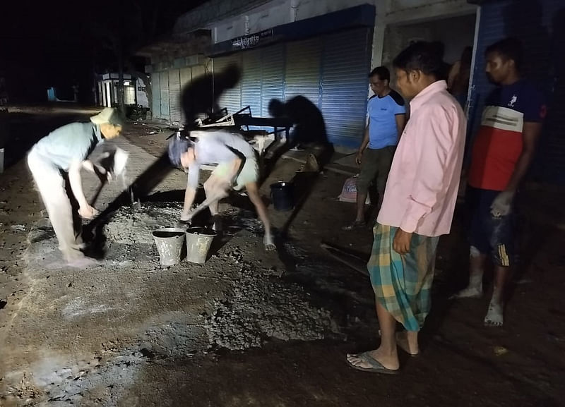 স্বেচ্ছাশ্রমে সড়কের গর্ত ভরাটের কাজ চলছে। গতকাল শনিবার রাতে মৌলভীবাজারের বড়লেখার কাঁঠালতলী-তেরাকুড়ি সড়কের সাইডিং বাজারে