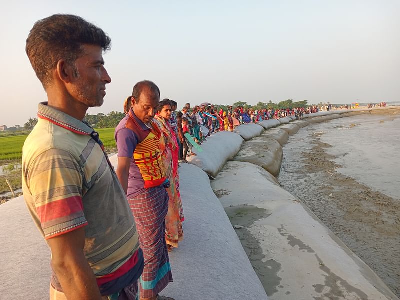 খুলনার পাইকগাছা উপজেলার দেলুটি ইউনিয়নের কালীনগর গ্রামে ভদ্রা নদীর ভাঙনকবলিত বেড়িবাঁধ এলাকায় স্থানীয় বাসিন্দাদের মানববন্ধন