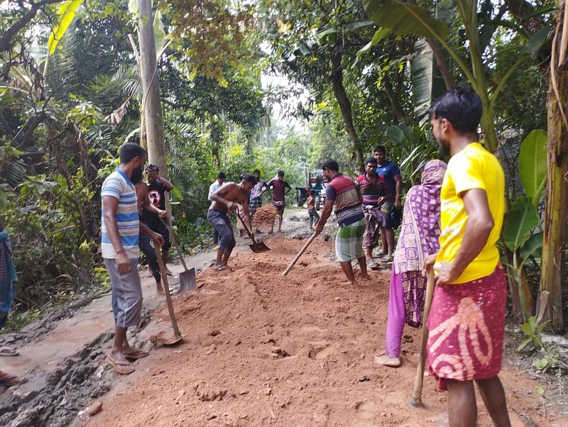 রাস্তার সংস্কারকাজে নারী-পুরুষ নির্বিশেষে অংশ নিচ্ছেন। গতকাল দুপুরে নাটোরে নলডাঙ্গা উপজেলার মোমিনপুর-কৃষ্ণপুরদীঘা সড়কে