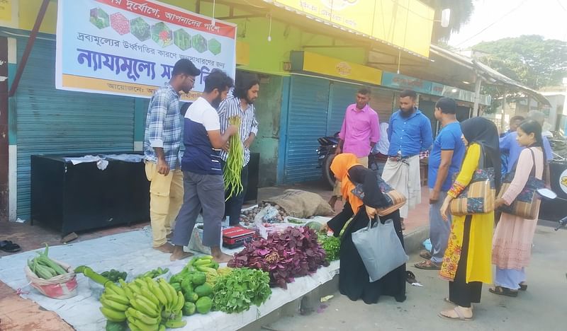 রাজশাহীতে শিক্ষার্থীদের ন্যায্যমূল্যের বাজার থেকে শাকসবজি কিনছেন এক নারী ক্রেতা। আজ সকালে রাজশাহী নগরের বিনোদপুর বাজারে