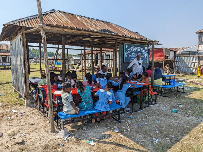 শরীয়তপুরের জাজিরা উপজেলার পদ্মা সেতু প্রকল্পের ফাঁকা জায়গায় একটি ঘরের বারান্দায় ও খোলা আকাশের নিচে পাইনপাড়া সরকারি প্রাথমিক বিদ্যালয়ের পাঠদান কার্যক্রম চালাচ্ছেন শিক্ষকেরা। গতকাল নাওডোবায়