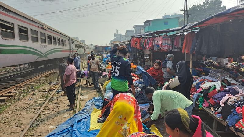 রেলপথের ওপর ঝুঁকিপূর্ণ অস্থায়ী বাজার। ট্রেন আসায় ক্রেতা-বিক্রেতাদের ছোটোছুটি। শনিবার 
সৈয়দপুর ২ নম্বর রেলগেট এলাকায়