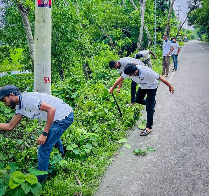 স্বেচ্ছাশ্রমে সড়কের পাশের ঝোপজঙ্গল পরিষ্কার করা হচ্ছে। ৫ অক্টোবর মৌলভীবাজারের চান্দগ্রাম–মৌলভীবাজার আঞ্চলিক মহাসড়কের বড়লেখা-চান্দগ্রাম অংশে