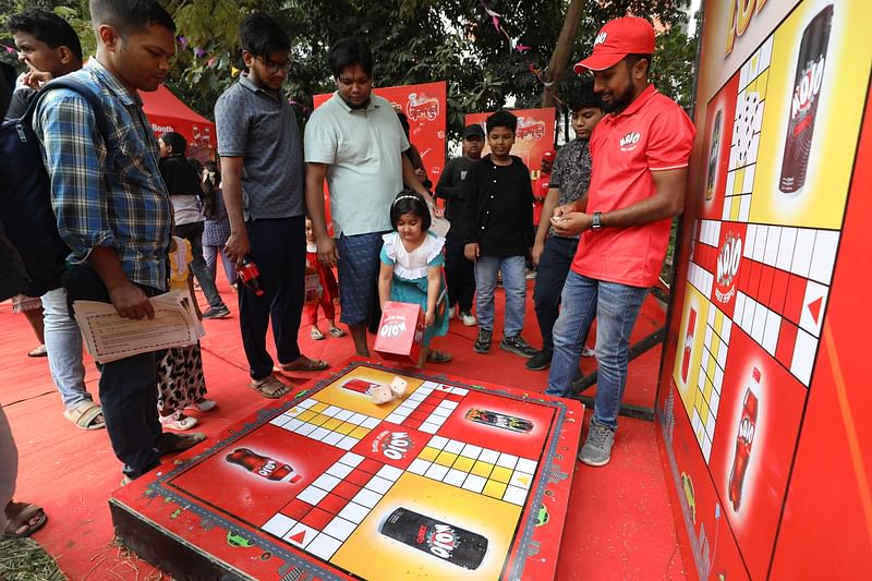 উপহার পাওয়ার জন্য লুডুর বোর্ডে ছক্কা ফেলছে এক শিশু।