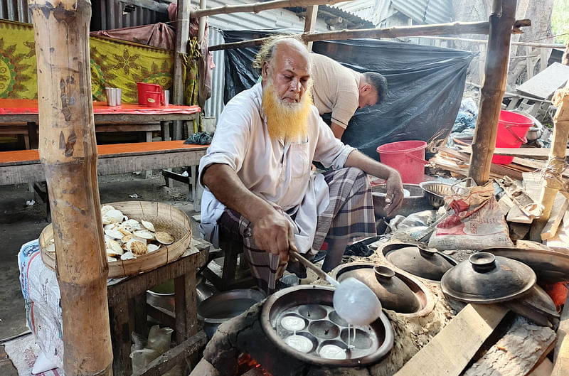 সাত পুতি পিঠা তৈরিতে ব্যস্ত মোজাহার আলী। সম্প্রতি রাজশাহীর বাগমারা উপজেলার ভবানীগঞ্জ হাটে