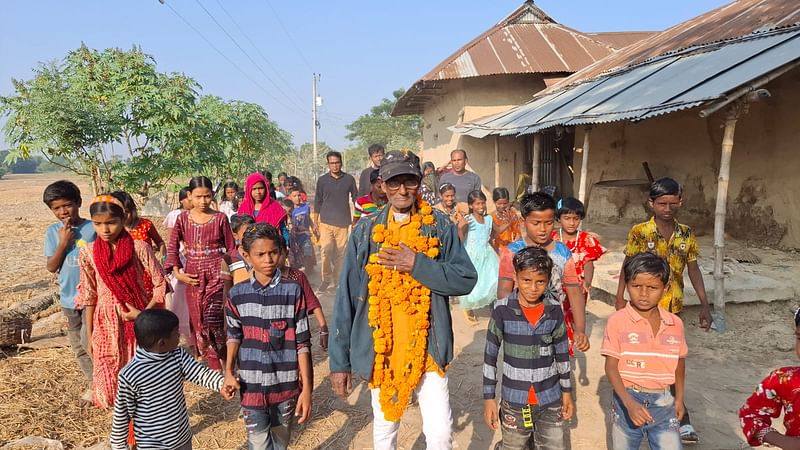 ফুলের মালা পরিয়ে বাড়ি থেকে মুক্তিযোদ্ধা জয়চাঁদ মণ্ডলকে নিয়ে আসছে শিশুরা। আজ সোমবার দুপুরে