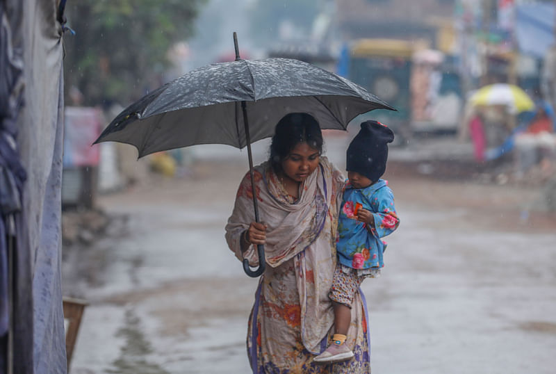 লঘুচাপের প্রভাবে গতকাল শুক্রবার মধ্যরাত থেকে টিপটিপ বৃষ্টি পড়ছে খুলনায়। আজ শনিবার শীতের সকালে বৃষ্টির মধ্যে ছাতা নিয়ে কাজের জন্য বাইরে বেরিয়েছেন এক নারী। বাস্তুহারা, খুলনা, ২১ ডিসেম্বর