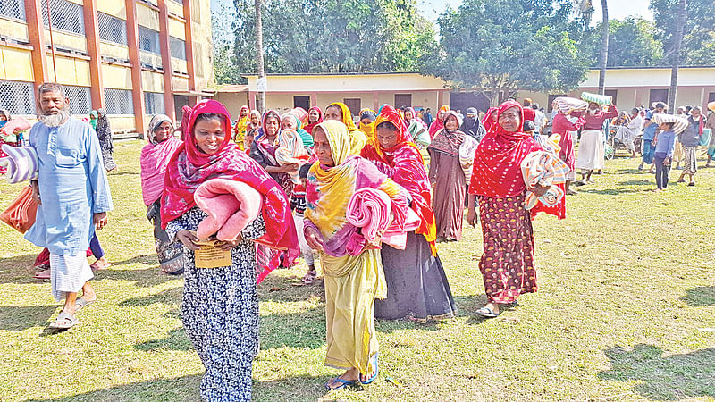 প্রথম আলো ট্রাস্টের উদ্যোগে বিতরণ করা কম্বল হাতে শীতার্ত মানুষ। গতকাল রাজশাহীর বাঘা উপজেলার আব্দুল গণি ডিগ্রি কলেজ মাঠে