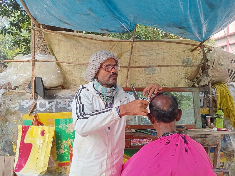 খুলনা জিলা স্কুলের পেছনের দিকে কেডি ঘোষ লিংক রোডের ফুটপাতেই চুল-দাড়ি কাটেন নির্মল শীল। গত রোববার তোলা