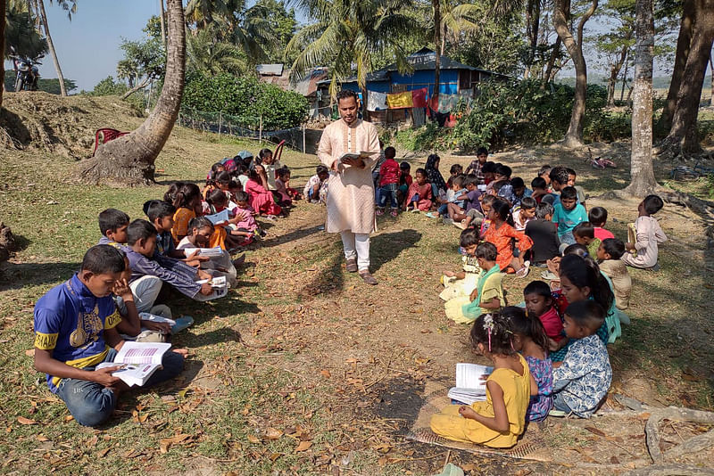 চট্টগ্রামের মিরসরাই উপজেলার সাহেরখালী ইউনিয়নের গজারিয়া গ্রামের উপকূলীয় বেড়িবাঁধ এলাকায় ‘গাছতলার বিদ্যালয়ে’ শিশুদের পড়াচ্ছেন ইকবাল হোসেন। সম্প্রতি তোলা