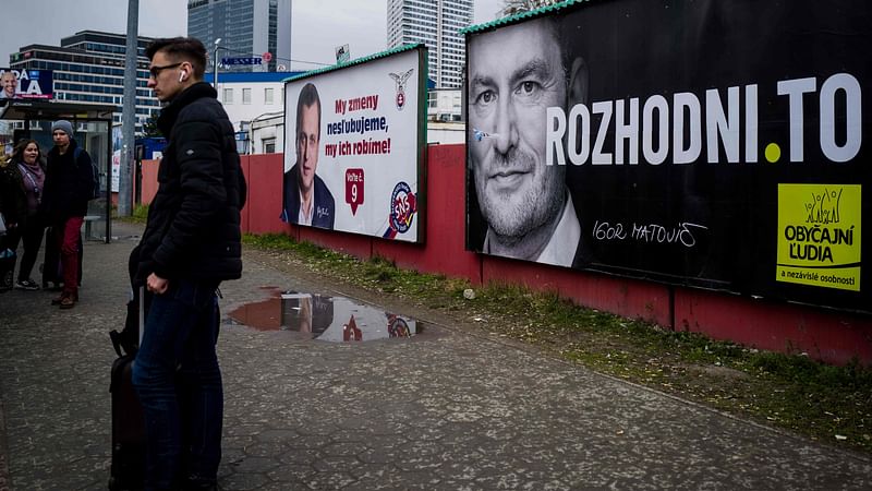 People wait for a bus in front of election posters on the eve of the country's parliamentary election in Bratislava, Slovakia on 28 February. Photo: AFP