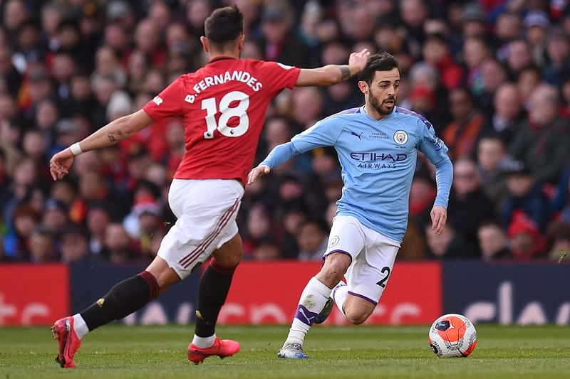 Manchester United's Portuguese midfielder Bruno Fernandes (L) vies for the ball with Manchester City's Portuguese midfielder Bernardo Silva during the English Premier League football match between Manchester United and Manchester City at Old Trafford in Manchester, north west England, on March 8, 2020.