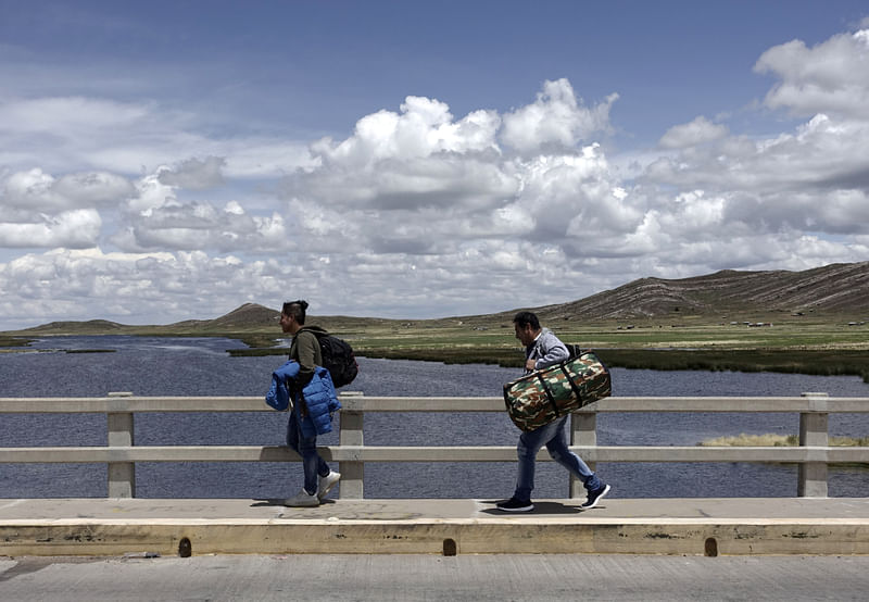 Stranded passengers cross the international bridge at the border between Peru and Bolivia, in Desaguadero, Bolivia, 17 March 2020. Reuters