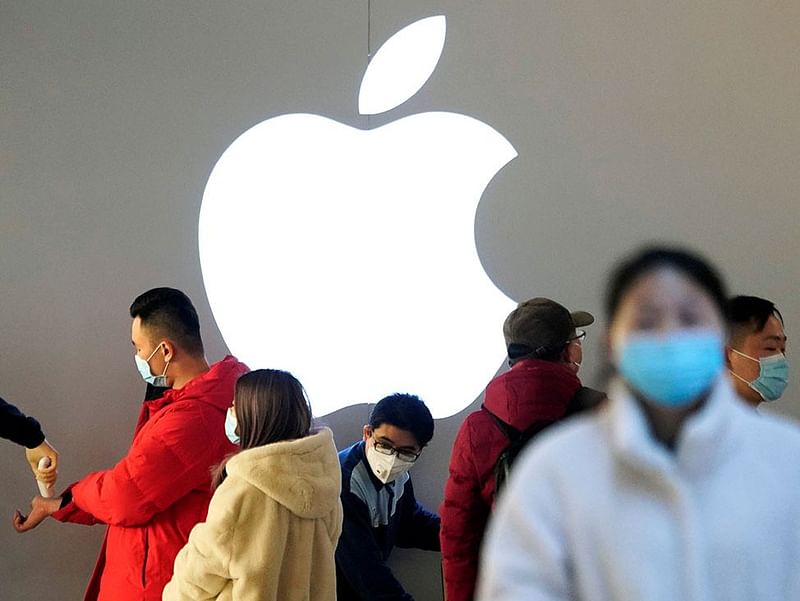 People wearing protective masks wait for checking their temperature in an Apple Store, in Shanghai. Photo: Reuters