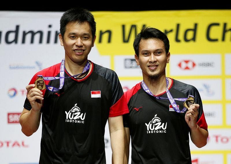 Indonesia's Mohammad Ahsan and Hendra Setiawan celebrate on the podium with medals after winning their men's doubles final match on 25 August, 2019.