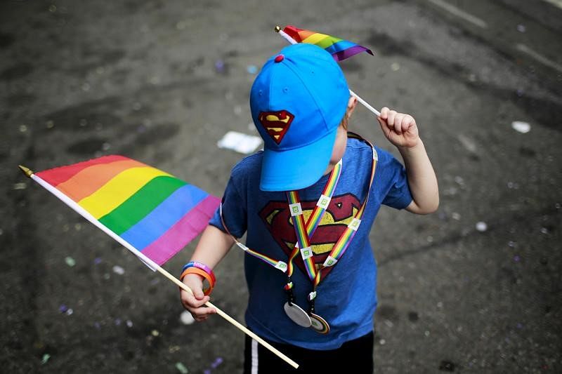 A child carries rainbow flags while he takes part in a march during the annual Gay Pride Parade in New York on 28 June 2015.