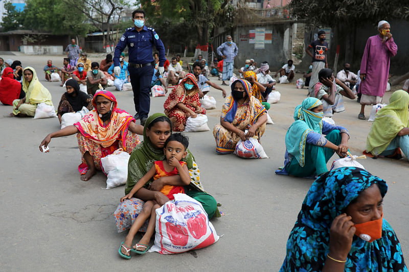 Women sit on the ground maintaining social distance waiting to receive relief supplies provided by local police authority amid the coronavirus disease (COVID-19) outbreak in Dhaka, Bangladesh, on 2 April 2020