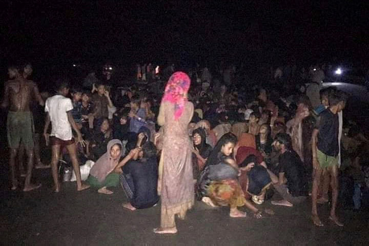 Rohingya refugees who were rescued by Bangladesh Coast Guard, sit on the shore in Teknaf, Cox's Bazar, Bangladesh on 15 April 2020