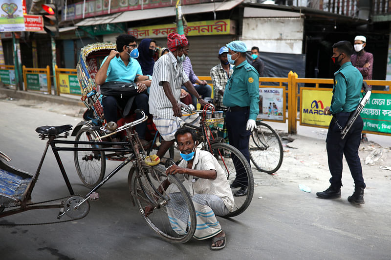 A rickshaw puller is forced to release air from tire by security personnel as a punishment during countrywide public transport shutdown imposed by the government amid the coronavirus disease (COVID-19) outbreak in Dhaka, Bangladesh, on 1 April 2020