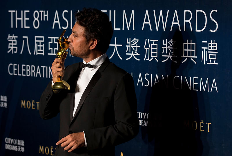 Indian actor Irrfan Khan kisses his trophy after winning the Best Actor for "The Lunchbox" at the 8th Asian Film Awards in Macau 27 March 2014.