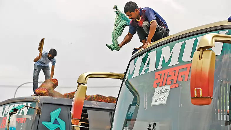 Transport workers clean buses after a long hiatus due to lockdown imposed across the country in a bid to contain coronavirus spread at Gabtali, Dhaka on 28 May 2020. The government allowed buses to restart on a limited scale from 1 June.