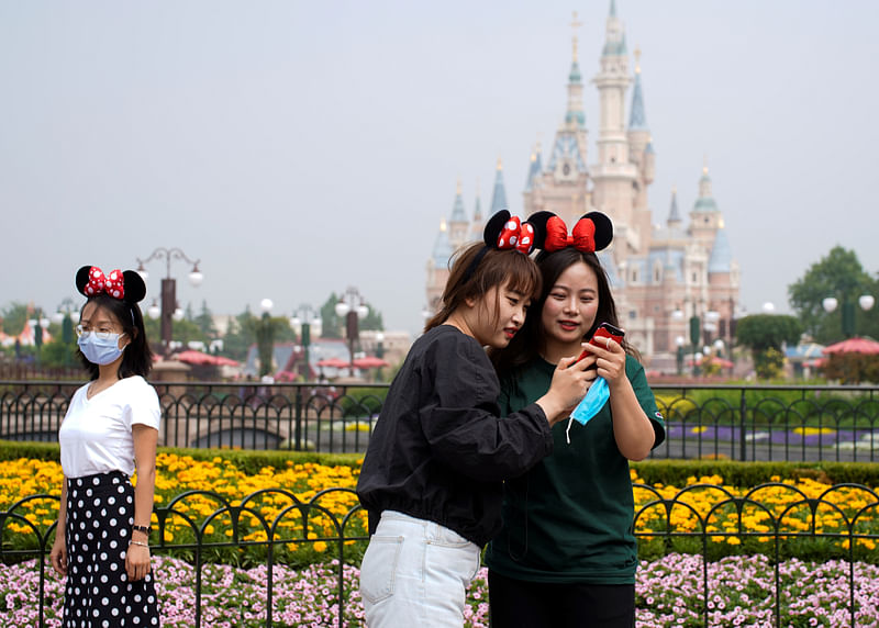 Visitors wear Minnie Mouse ears at Shanghai Disney Resort as the Shanghai Disneyland theme park reopens following a shutdown due to the coronavirus disease (COVID-19) outbreak, in Shanghai, China 11 May 2020.