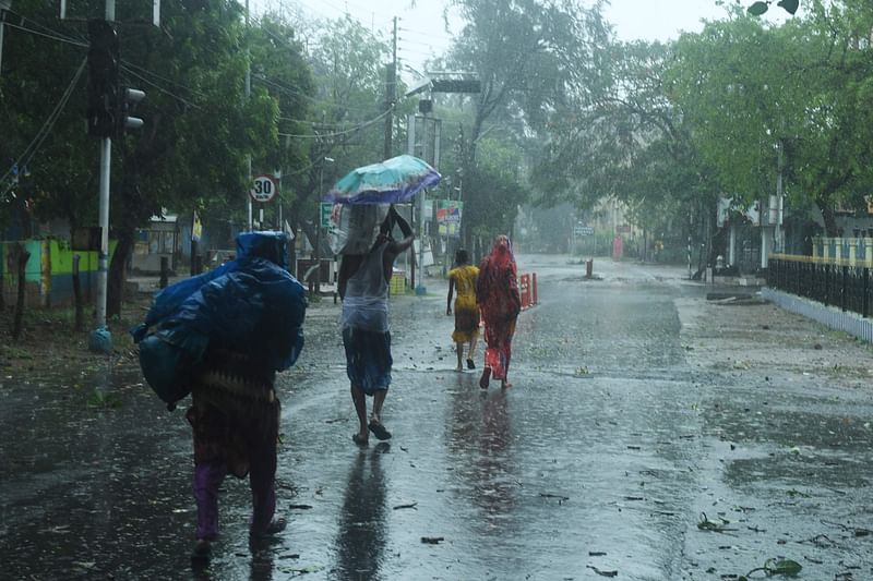 Residents walk along a street to a shelter ahead of the expected landfall of cyclone